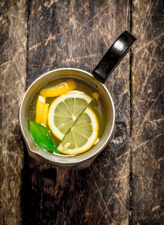 Fresh lemonade in a jug with slices of lemon . On wooden background.の写真素材
