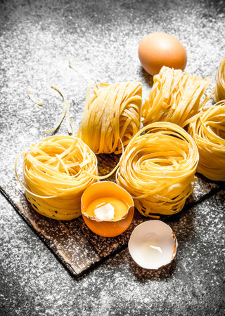Pasta background. Cooking homemade pasta with egg and flour. On rustic background.の写真素材