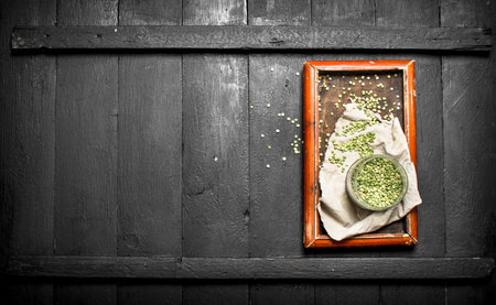 Green beans in bowl on old tray . On the black wooden table.の写真素材