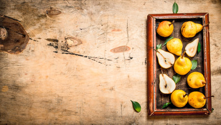 Fresh pears in the old tray. On wooden background.の写真素材