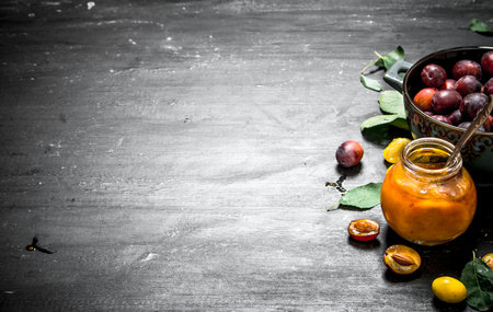 Fresh puree of ripe plums with green leaves. On a black chalkboard.の写真素材