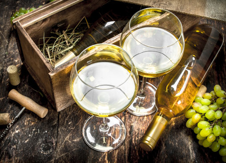 White wine in glasses. On a wooden background.の写真素材