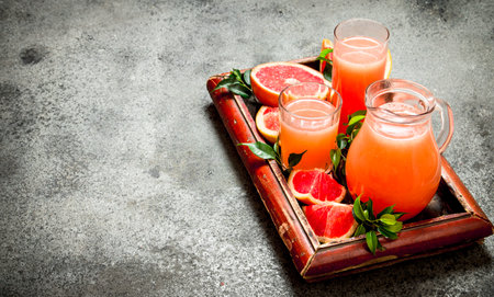 Freshly squeezed grapefruit juice. On rustic background.の写真素材