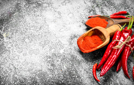 Ground red hot chili peppers in a bowl. On a rustic background.の写真素材