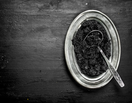 Black caviar in a bowl. On a black chalkboard.の写真素材