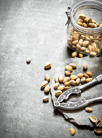Pistachios in the jar with the Nutcracker. On the stone table.の写真素材