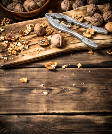 Walnuts with Nutcracker on the Board. On a wooden table.の写真素材