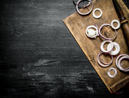 Fresh onion sliced on a wooden Board. On black rustic background.の写真素材
