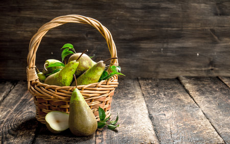 Fresh pears in a basket. On a wooden background.の写真素材
