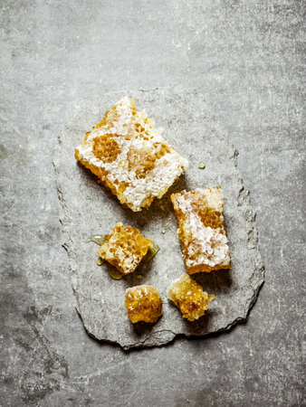 Natural honey comb on a stone stand . On a stone background.