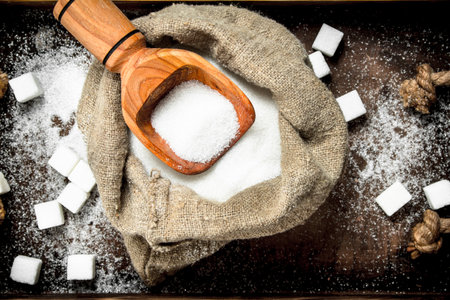 Sugar in an old sack with a scoop. On a rustic background.の写真素材