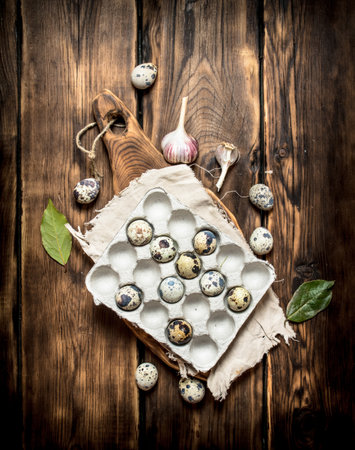 Quail eggs in a box with Laurel leaves. On a wooden tableの写真素材