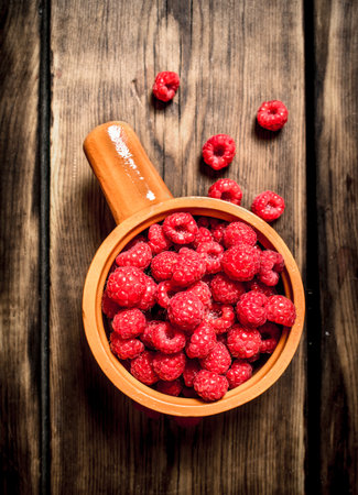 Wild raspberry in the Cup. On a wooden table.の写真素材
