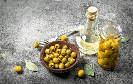 Pickled olives with olive oil. On a rustic background.の写真素材