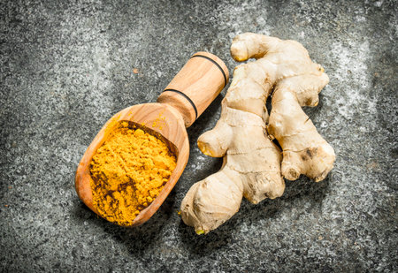 Ground ginger in a wooden scoop. On rustic background.の写真素材