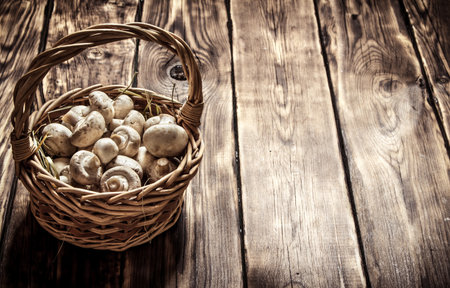 Fresh mushrooms in basket. On a wooden background.の写真素材