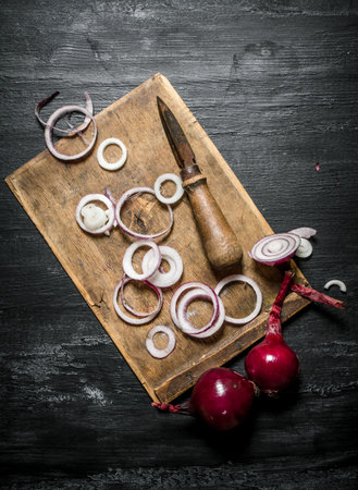 Fresh onion sliced on a wooden Board. On black rustic background.の写真素材