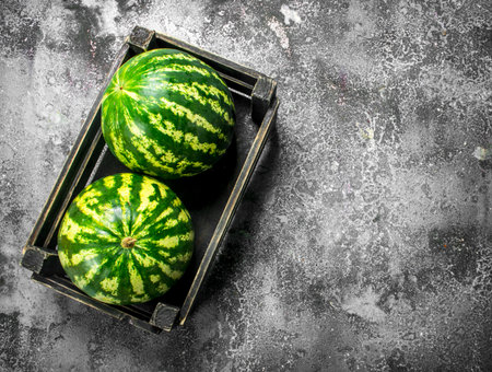 Fresh watermelons in a box. On a rustic background.の写真素材