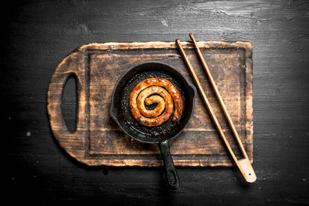 Sausage in the pan. On the black chalkboard.の写真素材