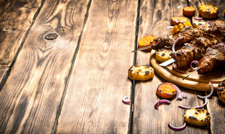 Shish kebab with grilled vegetables. On wooden background.の写真素材