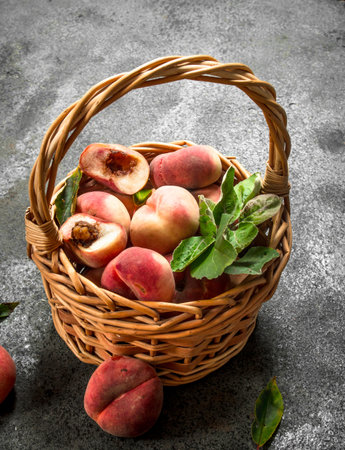 Ripe peaches in a basket. On a rustic background.の写真素材