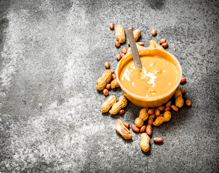 Nuts and peanut butter in a bowl. On rustic background.の写真素材