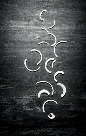Chopped fresh onion. On a black rustic background.