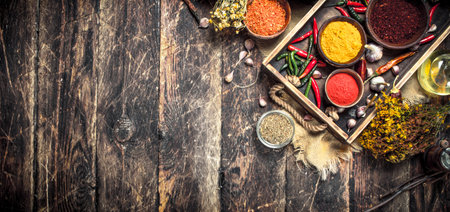 Various ground spices and herbs in an old tray. On a wooden background.の写真素材