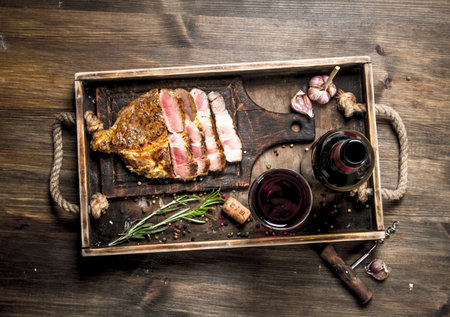 Beef grill with red wine. On a wooden table.の写真素材
