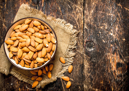 Almonds in a bowl. On wooden background.の写真素材