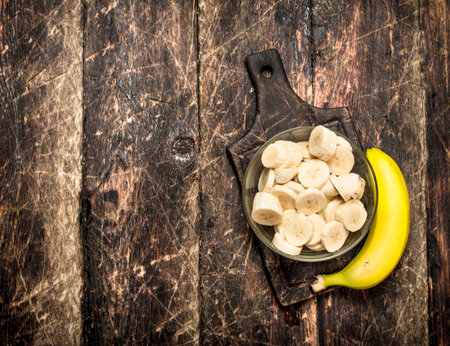 Sliced bananas in a bowl. On a wooden table.の写真素材