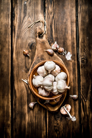Garlic background . Fresh garlic on old wooden Board. On wooden backgroundの写真素材