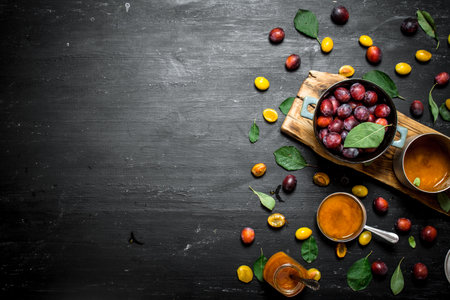 Fresh puree of ripe plums with green leaves. On a black chalkboard.の写真素材