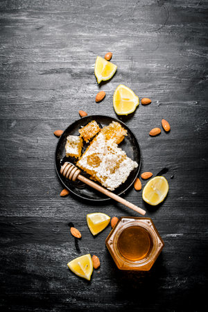 Honey background. Sweet natural honey with lemon . On black rustic background.の写真素材