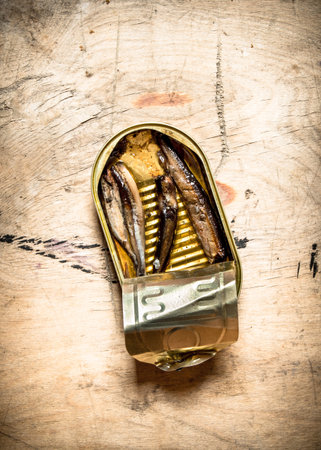 Smoked sprats in oil. On wooden background.の写真素材