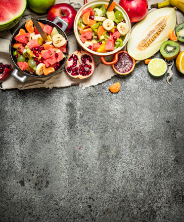 Tropical food . Fresh tropical fruit salad in bowls. On rustic background.の写真素材
