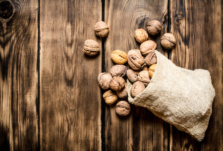 Walnuts in the old bag. On a wooden table.