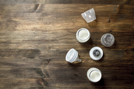 Baby food. Baby milk in small bottles. On a wooden table.