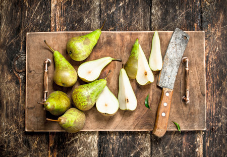 Slicing ripe pears on a cutting board. On a wooden background.の写真素材