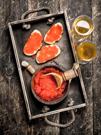 Sandwiches of caviar with white wine. On wooden background.の写真素材