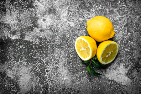 Fresh lemons with leaves. On a rustic background.の写真素材