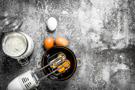 Baking background. Blend eggs with a mixer to make a dough. On a rustic background.の写真素材