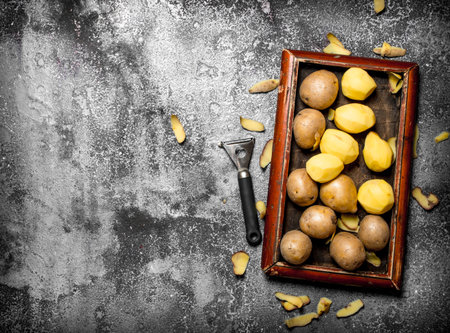Fresh potatoes in an old tray. On rustic backgroundの写真素材