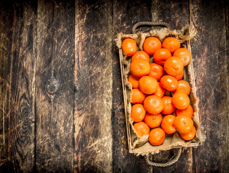 Fresh tangerines on a tray. On a wooden background.の写真素材