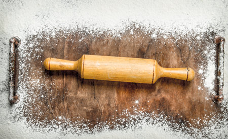 Baking background. Rolling pin for dough on the cutting board. On a rustic background.の写真素材