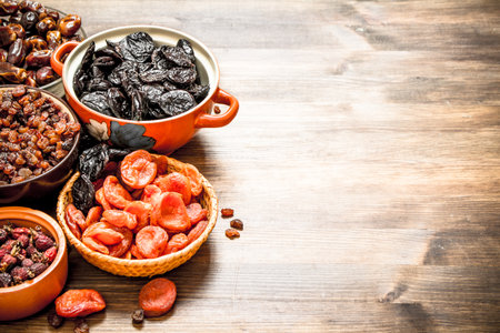 Dried fruits in bowls. On a wooden table.の写真素材