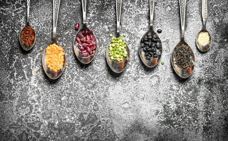 variety of bean seeds in spoons . On rustic background.の写真素材