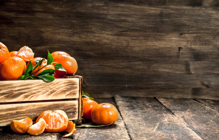 Ripe mandarins in an old box. On a wooden background.の写真素材