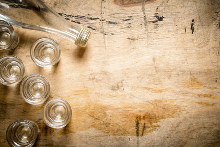 bottle of vodka with shot glasses. On wooden background.の写真素材