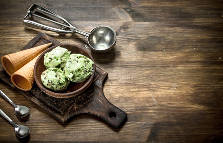 Fresh pistachio ice cream in a bowl with waffle cups. On a wooden table.の写真素材